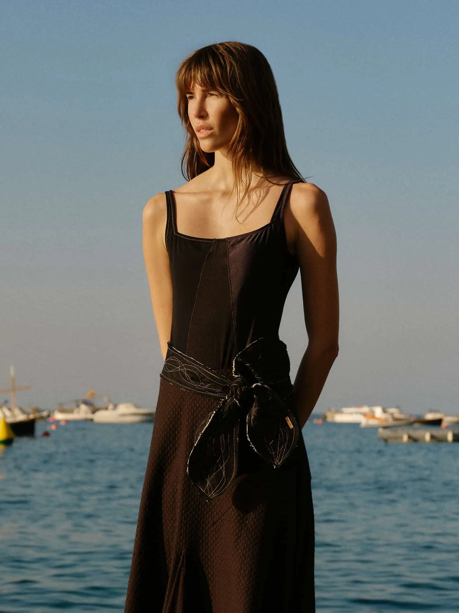 Modelo con vestido negro junto al mar